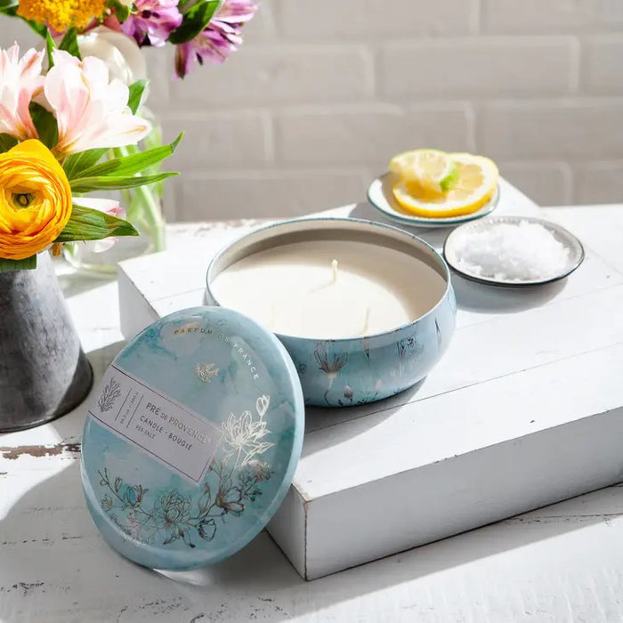 Round tin lid for the 3 Wick Candle - Sea Salt by European Soaps, LLC, features blue watercolor art, floral and seaweed designs, a flying bird, and “Parfum de France”—ideal for fans of unique signature fragrances.