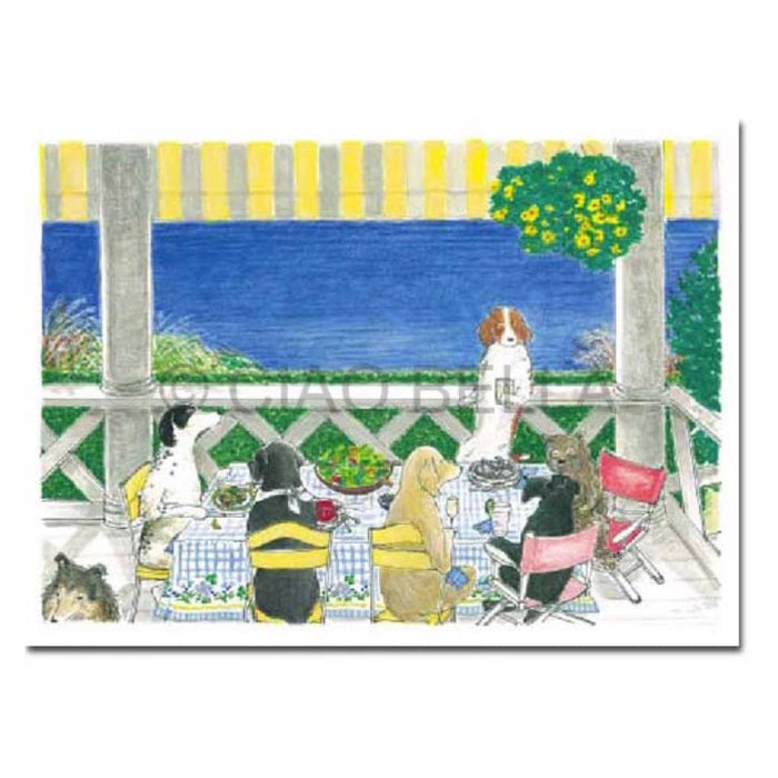 Six dogs in human clothes sit around a table set for a meal on an ocean-view porch, under a yellow-striped canopy with yellow flowers, featuring the CIAO BELLA - MAGGIE'S TABLE CARD from CIAO BELLA on the table.