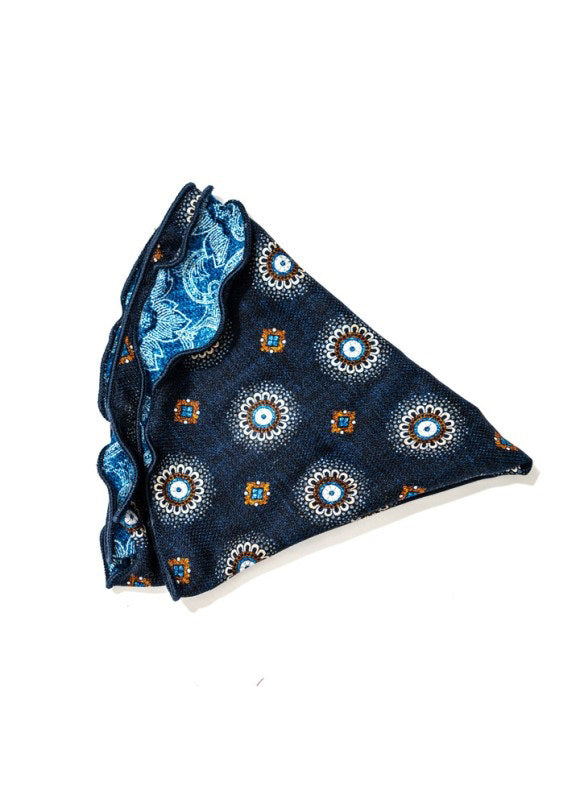 The EDWARD ARMAH - SILK REVERSIBLE POCKET CIRCLE IN NAVY MEDALLION features a crisp white background with navy medallion, floral, and geometric patterns, accented by light blue, white, and orange for a refined touch.