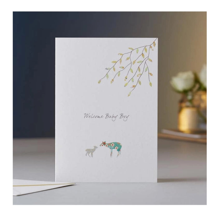 The ELOISE HALL - NEW BABY BOY CARD by ELOISE HALL LTD features a deer and fawn under leafy branches on a neutral background with softly blurred flowers, making it a luxury stationery choice.