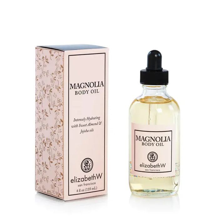 A 4 oz bottle of E WIGHTMAN & CO Magnolia Body Oil with a dropper lid is placed beside its corresponding box. The box, adorned with a floral design and text that reads "MAGNOLIA BODY OIL" and "E WIGHTMAN & CO," highlights the rich infusion of scented oil. Both the box and bottle labels match in design and color.