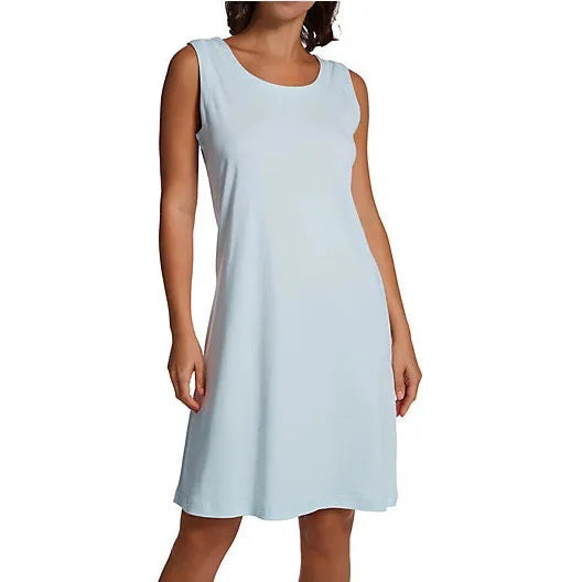 A woman models the FASHIONVIEWS P. JAMAS - BUTTERKNIT SLEEVELESS SHORT GOWN, a lightweight, knee-length white pima cotton dress, standing against a plain white background with arms relaxed at her sides and face partially out of frame.