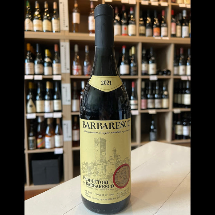 A 2021 PRODUTTORI DEL BARBARESCO red wine by WINE: JOHNSON BROS./OXFORD ST., made from Nebbiolo grapes, with a yellow label featuring a castle illustration and a red seal.