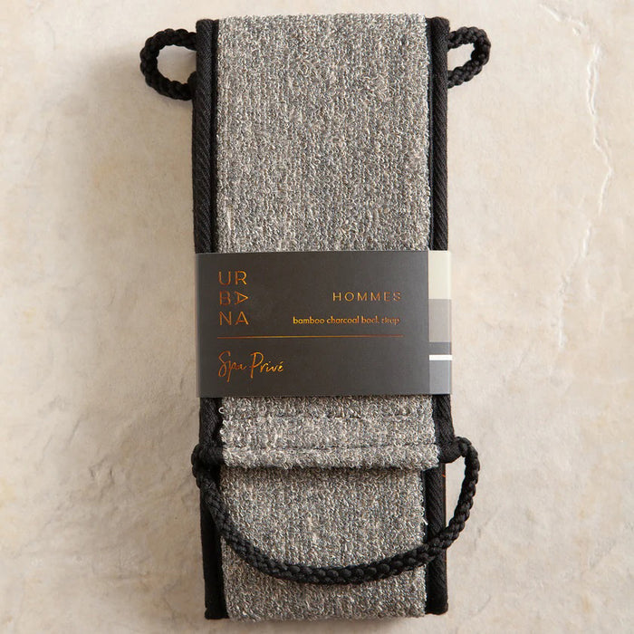 The BAMBOO CHARCOAL BACK SCRUBBER by EUROPEAN SOAPS, LLC is a gray rectangular sheath with black trim and two rope loops, designed to securely hold exfoliating tools for removing dead skin cells or unclogging pores.
