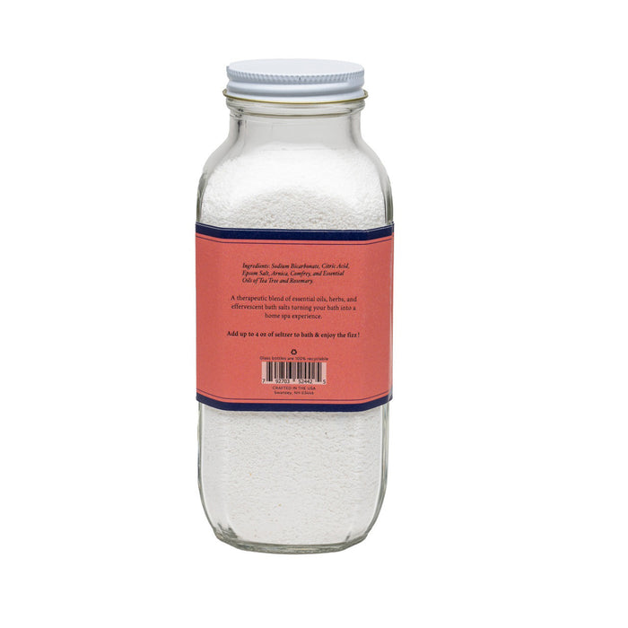 A clear glass jar of BAUDELAIRE - RECOVER BATH SELTZER 18OZ, featuring a pink and blue label, is filled with white bath salts for soothing soaks. Brand: BAUDELAIRE.