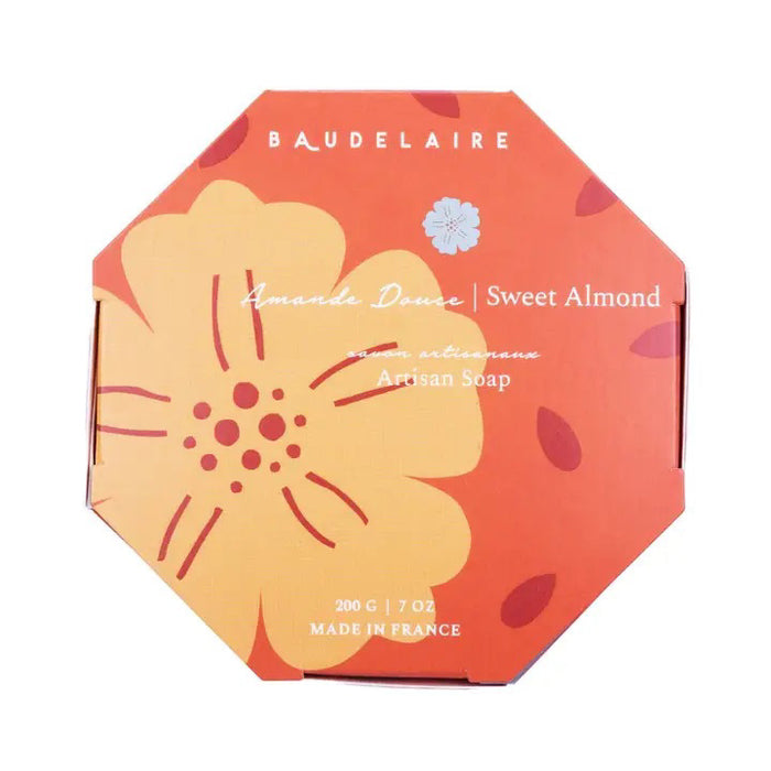 An orange, octagonal box labeled "BAUDELAIRE - SWEET ALMOND 7OZ BOXED BATH BAR" with a large yellow flower illustration. This French-milled soap is 7oz, made in France, and features English and French text.