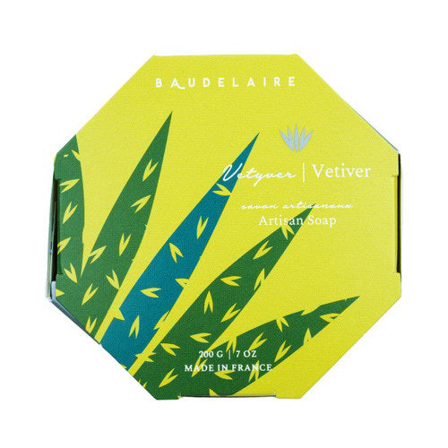 A yellow, octagonal box featuring green leaf patterns and blue accents holds the BAUDELAIRE - VETIVER 7OZ BOXED BATH BAR. The packaging indicates 200g (7oz) and “Made in France,” emphasizing this French-milled vetiver bath bar from Baudelaire with a sophisticated unisex fragrance.