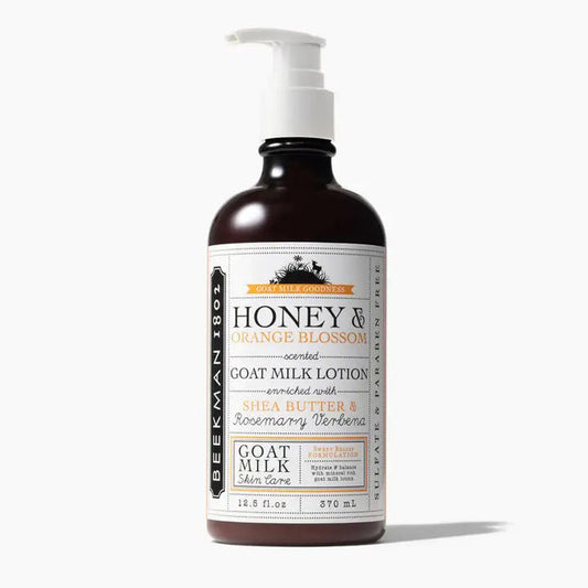A brown bottle with a white pump labeled "BEEKMAN - HONEY AND ORANGE HAND LOTION 12.5OZ" from BEEKMAN - STA ELEMENTS, offering moisturizing hand care with a citrus scent in a 12.5 oz size.