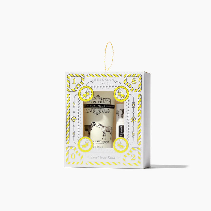 The BEEKMAN - PURE GOAT MILK HAND AND LIP BALM SET by BEEKMAN - STA ELEMENTS comes in a festive white and yellow box with a window, hanging loop, and "Sweet to be Kind" on the front.