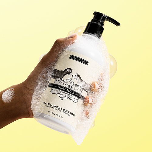 A white pump bottle of BEEKMAN - PURE GOAT MILK HAND & BODY WASH by BEEKMAN - STA ELEMENTS features two goats facing each other and offers a fragrance-free, paraben-free goat milk prebiotic formula for nourishing skin.