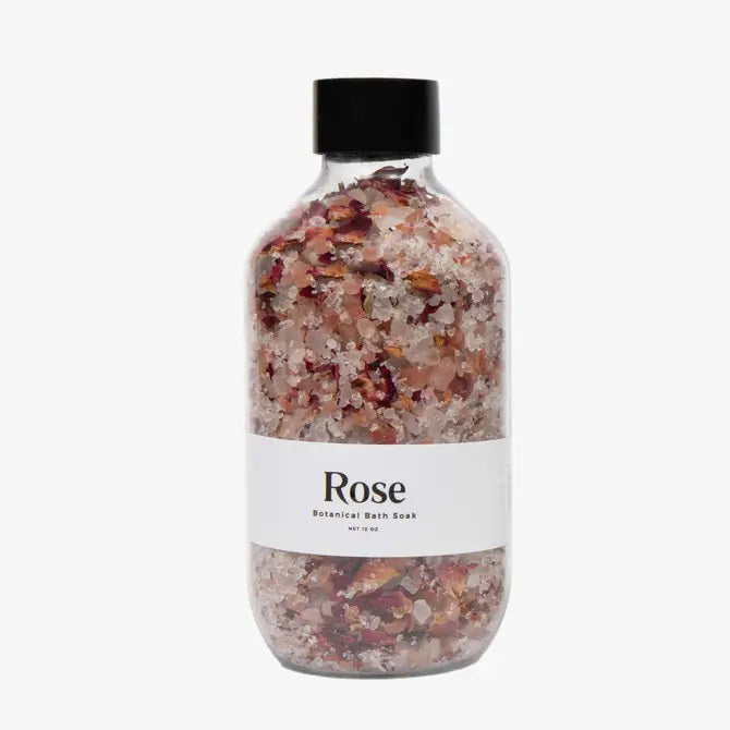 A clear bottle from GIFTEN MARKET holds pink and white BOTANICAL BATH SOAK - ROSE with dried rose petals. The label displays "Rose Botanical Bath Soak" on a white background.