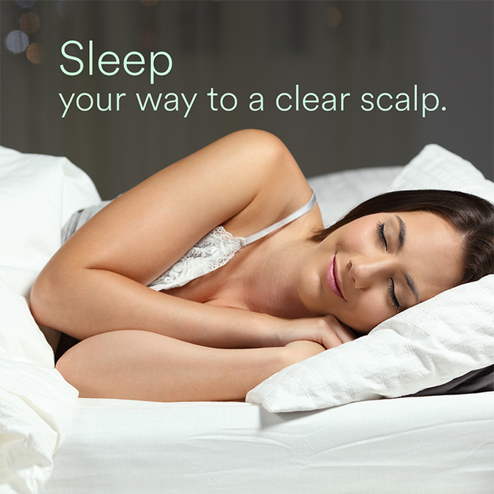 Woman peacefully sleeping on white bed with text “Sleep your way to a clear scalp.”