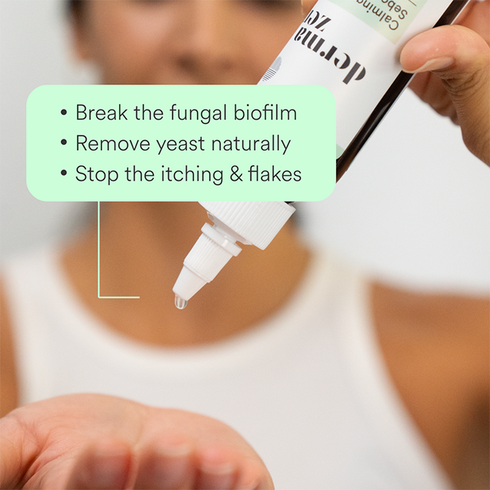 Hand holding a bottle of Dermazen Calming Seborrheic Serum with text “Break the fungal biofilm, remove yeast naturally, stop the itching & flakes.”