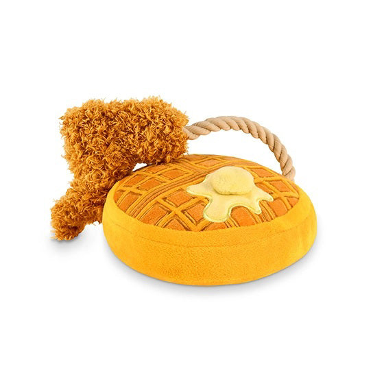 The PLAY PET LIFESTYLE CHICKEN & WOOFLES is a bright orange and yellow plush dog toy shaped like a waffle with a butter pat and fried chicken, joined by a rope. Durable, machine washable, and perfect for brunch-loving pups!.