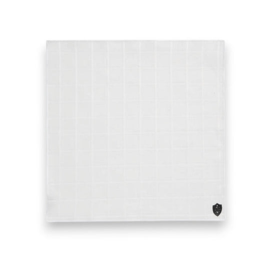 The CLIFTON WILSON - WHITE LINEN WINDOWPANE POCKET SQUARE features a subtle check pattern and a small black logo in one corner, shown neatly folded on a white background.