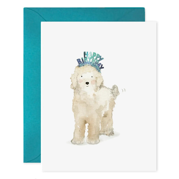 The E. FRANCES PAPER "Lucy Dog Birthday" card features a fluffy white dog in a blue birthday headband, paired with a teal envelope and printed on luxe heavyweight paper.