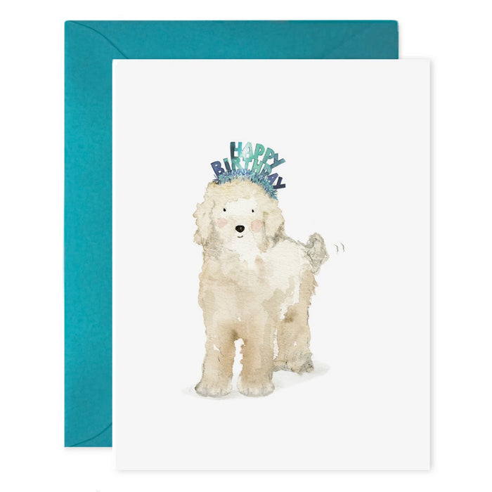 The E. FRANCES PAPER "Lucy Dog Birthday" card features a fluffy white dog in a blue birthday headband, paired with a teal envelope and printed on luxe heavyweight paper.