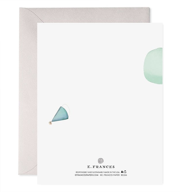 The E. FRANCES - POGO PANDA greeting card by E. FRANCES PAPER features a panda on a pogo stick with a green balloon and “Happy Birthday” below, printed on heavyweight paper and paired with a grey envelope behind the card.