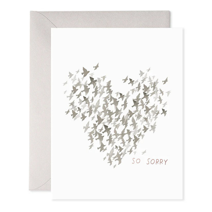 The E. FRANCES PAPER - STARLINGS CONDOLENCE GREETING CARD features a heart made of small gray birds on luxurious paper. Below, "SO SORRY" is printed in muted pink. An elegant envelope is partially visible behind the card.
