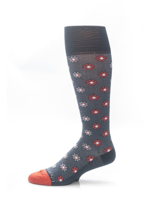 The EDWARD ARMAH - NAVY RED FLORAL SOCK is a single knee-high navy sock featuring red and white floral patterns, with solid orange toe and heel, displayed upright on a white background.