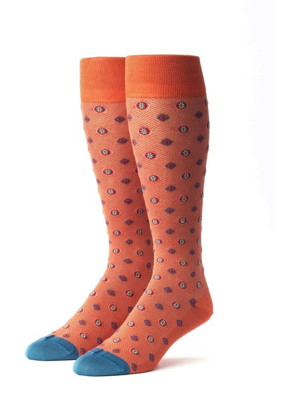 EDWARD ARMAH - ORANGE RED TEAL FOULARD SOCKS: Knee-high cotton socks in orange, featuring small blue, red, and white foulard patterns, orange cuffs, and blue toe tips. Displayed upright on a white background.