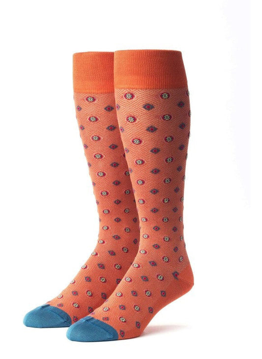 EDWARD ARMAH - ORANGE RED TEAL FOULARD SOCKS: Knee-high cotton socks in orange, featuring small blue, red, and white foulard patterns, orange cuffs, and blue toe tips. Displayed upright on a white background.