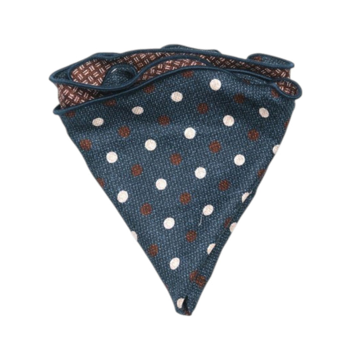 The EDWARD ARMAH - SILK REVERSIBLE POCKET CIRCLE NAVY DOTS is shown neatly folded on a white background, highlighting its blue side with white and brown polka dots and contrasting geometric pattern on the reverse.