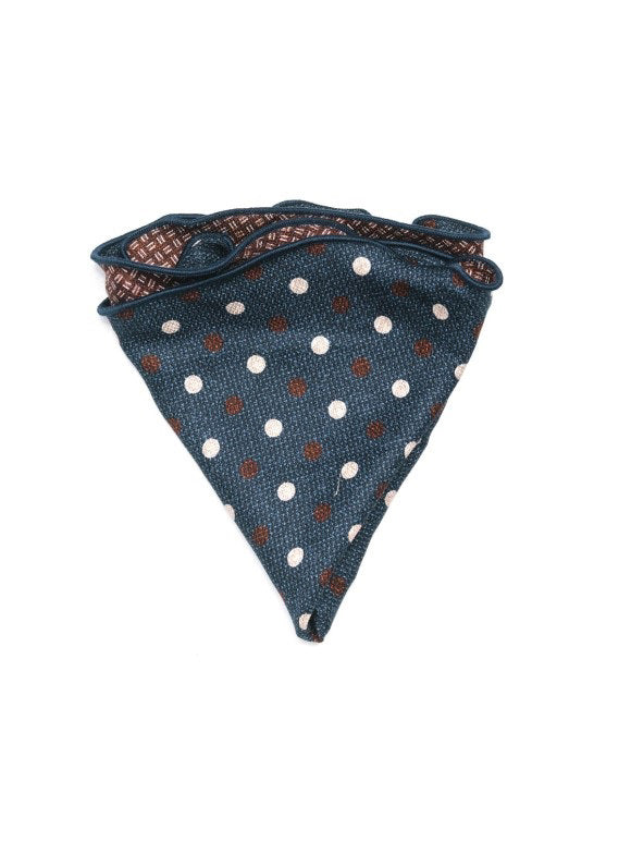 The EDWARD ARMAH - SILK REVERSIBLE POCKET CIRCLE NAVY DOTS is shown neatly folded on a white background, highlighting its blue side with white and brown polka dots and contrasting geometric pattern on the reverse.