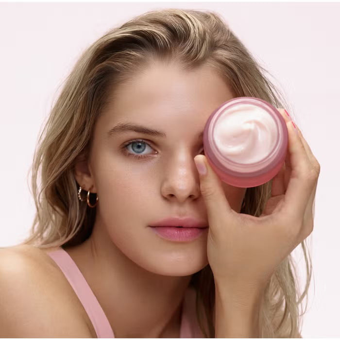 A pink frosted jar of ELEMIS - PRO-COLLAGEN ROSE MARINE CREAM by ELEMIS - STEINER sits open, revealing a swirl of light pink, rose-infused cream inside. The label reads “Hydrating day cream.”.