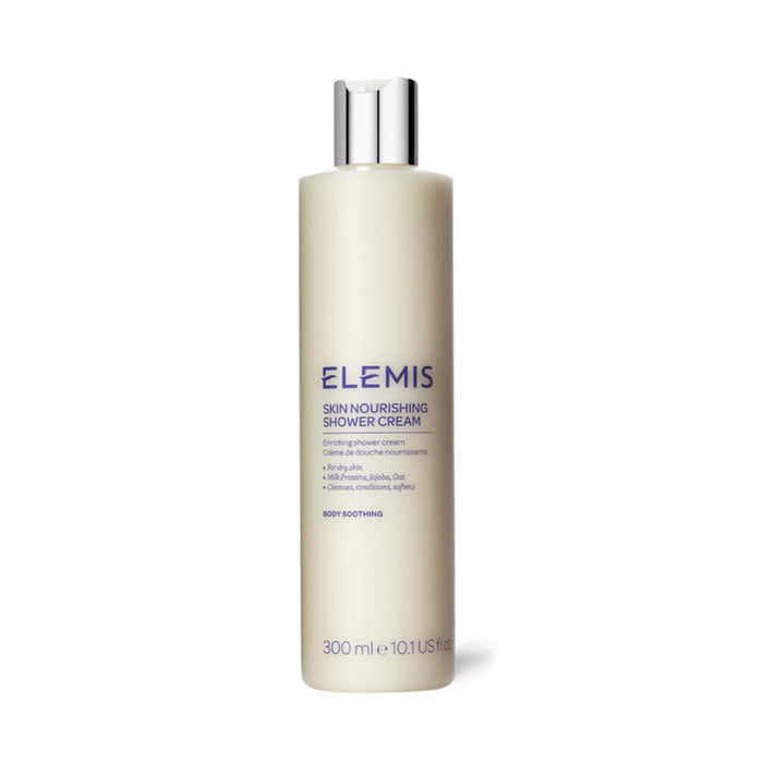 A beige bottle of ELEMIS - SKIN NOURISHING SHOWER CREAM by ELEMIS - STEINER with a silver cap; blue text label shows it's a 300ml (10.1 US fl.oz) cream designed to soothe the body and leave skin soft.