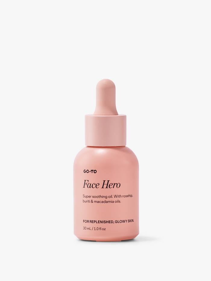 Pink bottle of Go-To Face Hero oil with dropper, featuring rosehip, buriti, macadamia oils for glowy, replenished skin.