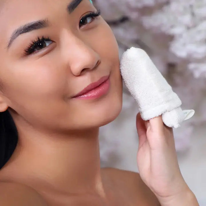 A white DAILY CONCEPTS FACIAL MICRO SCRUBBER, a gentle exfoliator and make-up remover for sensitive skin, comes in pink and white packaging that highlights its organic cotton content.