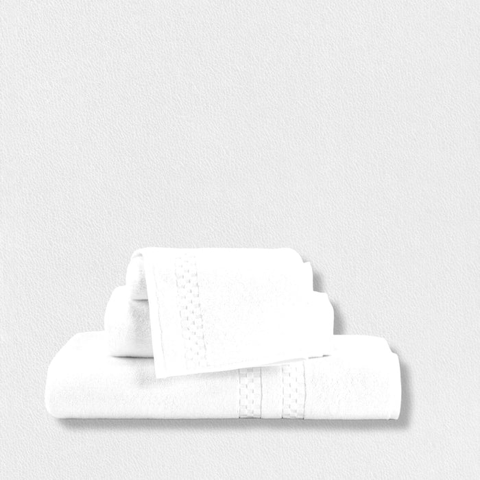 The FEARRINGTON LIFESTYLE TOWEL COLLECTION - WASH CLOTH by Frette North America features a plush cotton wash cloth in luxury white with a textured decorative band, neatly folded on a light, plain background.
