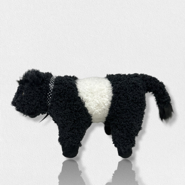 The FEARRINGTON SIGNATURE COLLECTION - BELTIE COW PLUSH TOY by BEVERLY HILLS TEDDY BEAR CO features a fluffy black and white cow design, with a white midsection and black head, legs, and tail, standing on a light surface against a plain background.