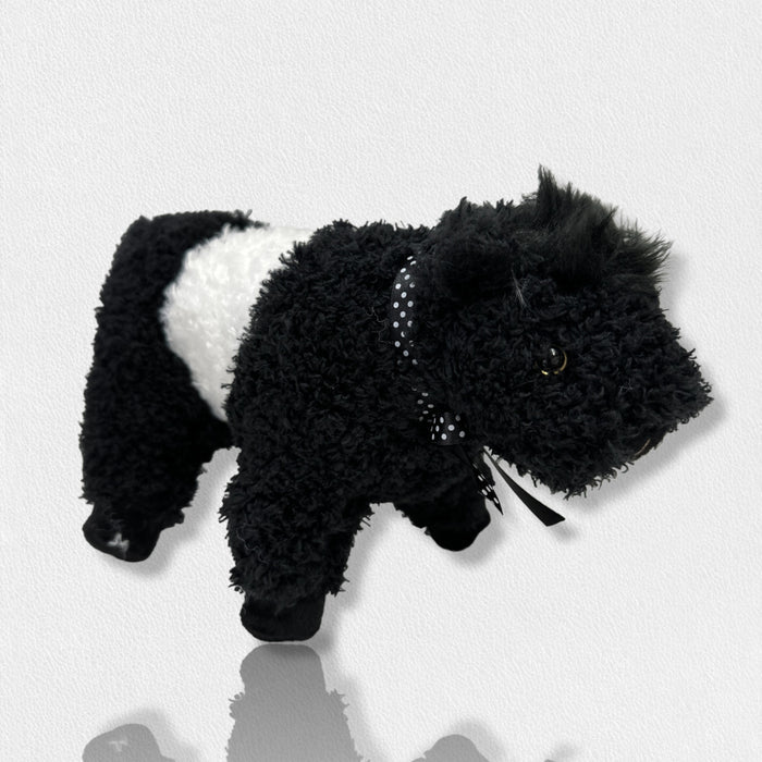 The FEARRINGTON SIGNATURE COLLECTION - BELTIE COW PLUSH TOY by BEVERLY HILLS TEDDY BEAR CO features a fluffy black and white cow design, with a white midsection and black head, legs, and tail, standing on a light surface against a plain background.