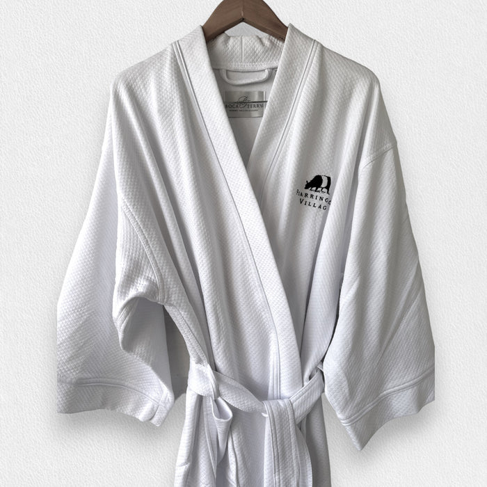 The BOCA FEARRINGTON SIGNATURE COLLECTION - FEARRINGTON VILLAGE ROBE is a folded white waffle-knit kimono collar bathrobe featuring a black bear logo and "Fearrington Village" embroidered on the chest, displayed on a light textured surface.