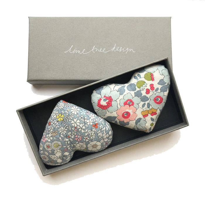 A grey gift box from LIME TREE COLLECTION LTD contains two handmade HEARTS - LOVE HEART SACHETs, one blue-white floral and one colorful floral—perfect as lavender drawer sachets.