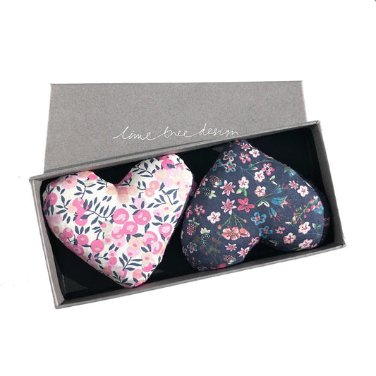 Two fabric heart-shaped LIME TREE COLLECTION LTD "HEARTS - LOVEY DOVEY SACHET" in pink floral and dark blue Liberty Tana Lawn are presented in a grey "lime tree design" box. Ideal as lavender drawer sachets.