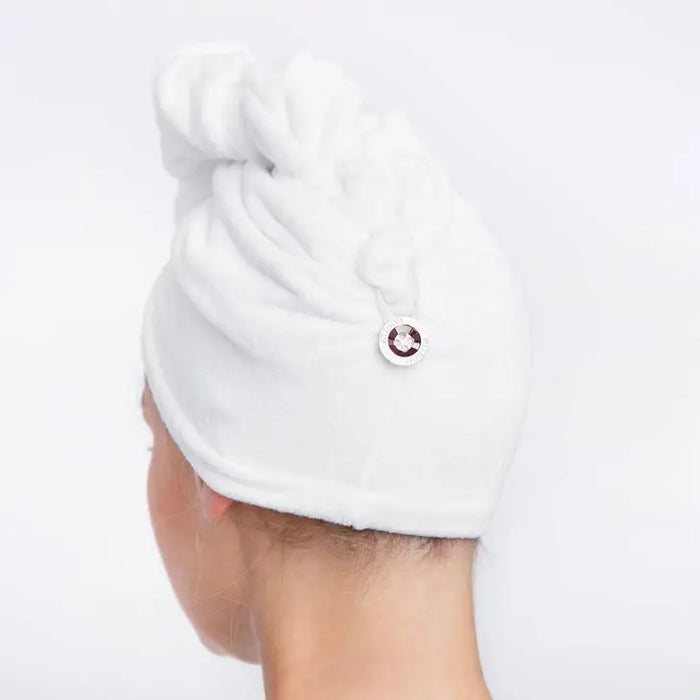 The KITSCH - QUICK DRY HAIR TOWEL, suitable for frizzy, curly, or straight hair, comes in a clear plastic bag labeled "/kit·sch/ CLEANSE," and boasts quick-drying microfiber that effectively reduces frizz.
