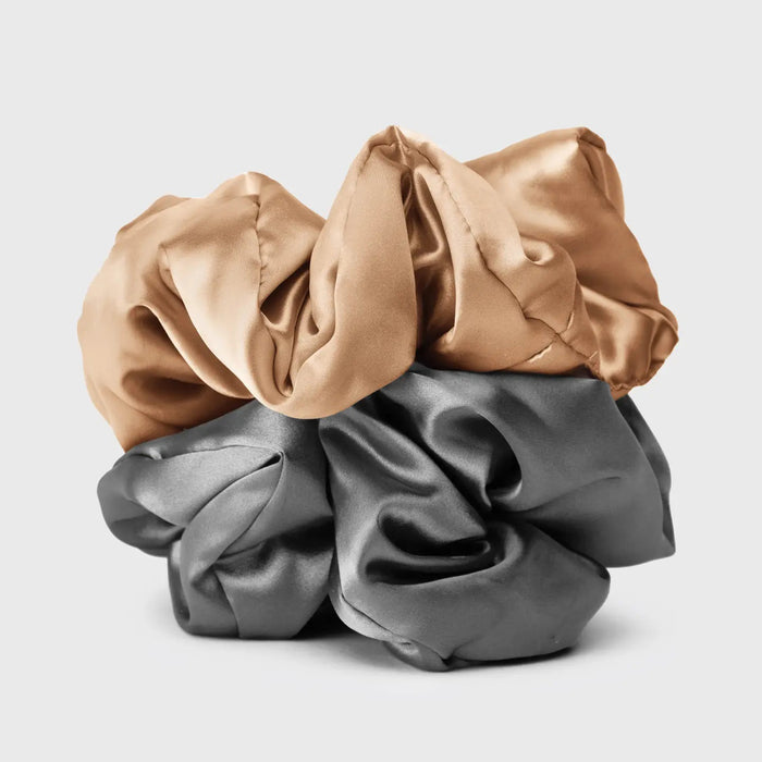A KITSCH - SATIN SLEEP PILLOW SCRUNCHIES box includes two large satin scrunchies—one gold, one gray—shown outside the box to showcase their soft, frizz-reducing texture.
