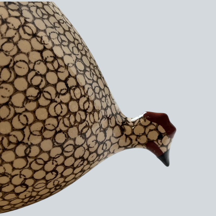 A handcrafted ceramic sculpture by LES CERAMIQUES DE LUSSAN, the Pecking Ceramic French Guinea Fowl in White Spotted Black, displays a striking black body adorned with white spots and stands on a pale cylindrical base against a minimalist white background—capturing the enduring elegance of South of France pottery.