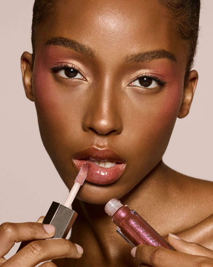 deep skin toned model wearing gloss bomb universal lip luminizer in shade Hot Chocolit