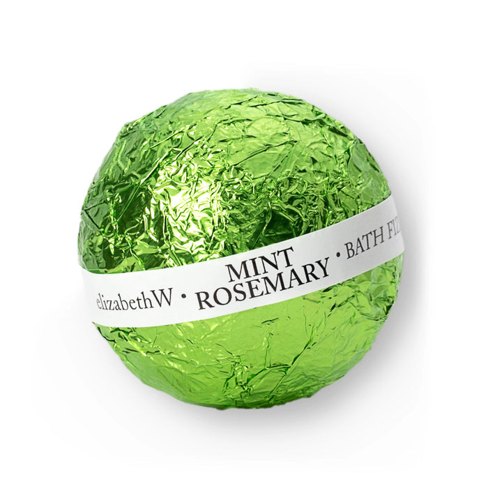 A green foil-wrapped MINT ROSEMARY BATH FIZZ BALL from E WIGHTMAN & CO, featuring a white label, offers a fragrant fizz experience against a crisp white background.