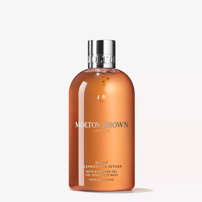 A bottle of MOLTON BROWN - SUNLIT CLEMENTINE & VETIVER BODY WASH with vibrant orange liquid and a silver cap stands upright on a white background—a luxurious citrus body wash by MOLTON BROWN.