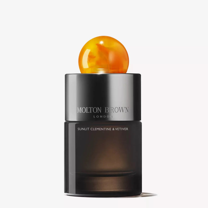 A black MOLTON BROWN SUNLIT CLEMENTINE & VETIVER Eau de Parfum bottle with a large marbled orange cap hints at citrus and vetiver notes, set against a plain white background.