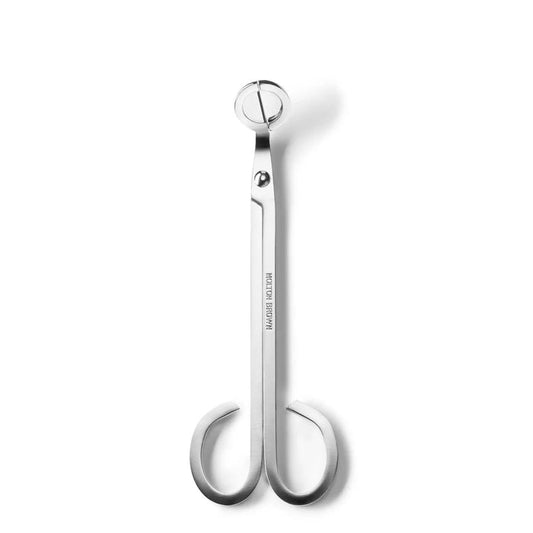 The MOLTON BROWN WICK TRIMMER features sleek stainless steel with a silver finish, circular blades, and curved handles—perfect for trimming scented candle wicks. The tool is shown vertically against a white background.