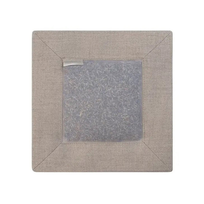 The SQUARE LAVENDER SACHET IN NATURAL LINEN by E WIGHTMAN & CO is a beige linen square with a transparent center showing dried lavender inside, neat stitching, and a small label—ideal for fragrancing tiles or clothes.