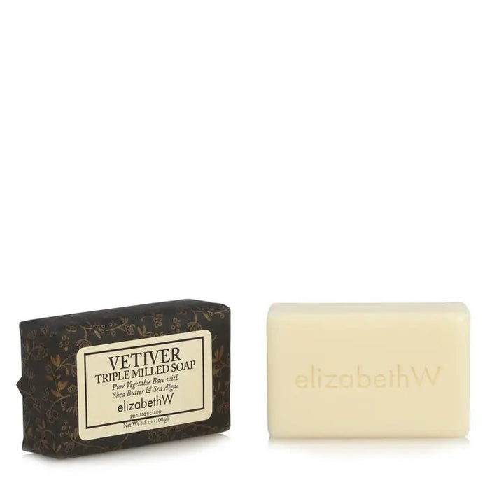 A rectangular bar of E WIGHTMAN & CO VETIVER TRIPLE MILLED SOAP 3.5OZ, enriched with shea butter and embossed with "elizabethW," sits beside its dark floral box detailing product name and ingredients.